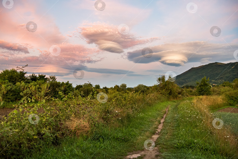 Скачать Удивительные разноцветные линзовидные облака над горой в сельской местности на пешеходном маршруте. Ирун, Страна Басков, Испания. фотосток Ozero