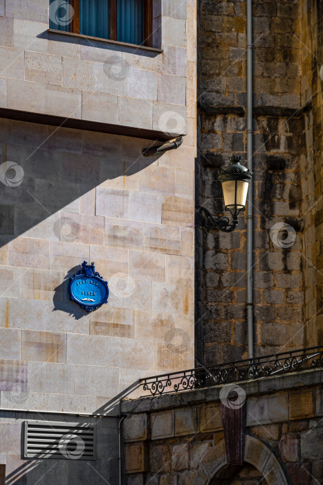 Скачать Общественный уличный знак синего цвета на стене на улицах Герники, Страна Басков, Испания. Название площади Элай-Алай Плаза фотосток Ozero