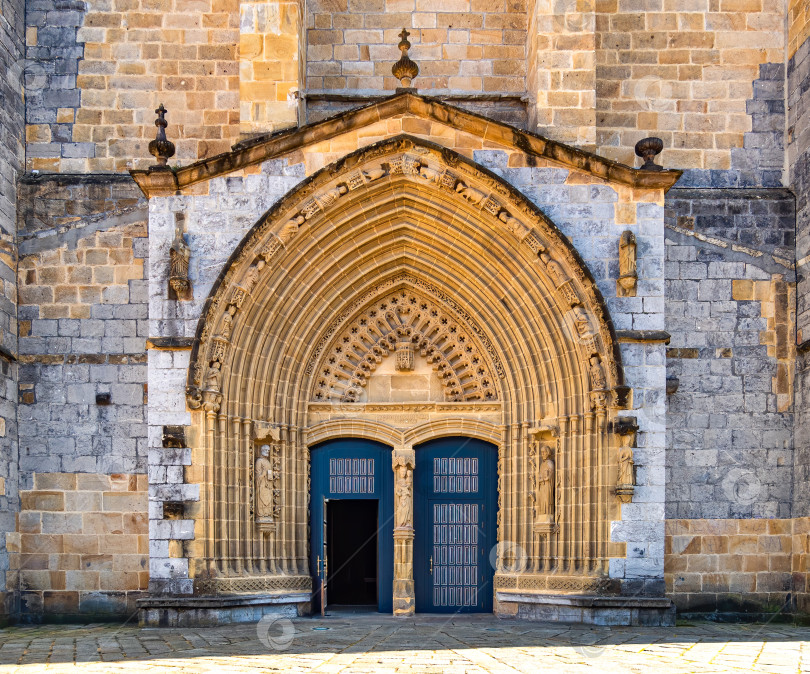 Скачать Входная дверь и главный фасад старой каменной церкви Андра Мария в Гернике, Страна Басков, Испания. Арка, ведущая в средневековый собор. фотосток Ozero