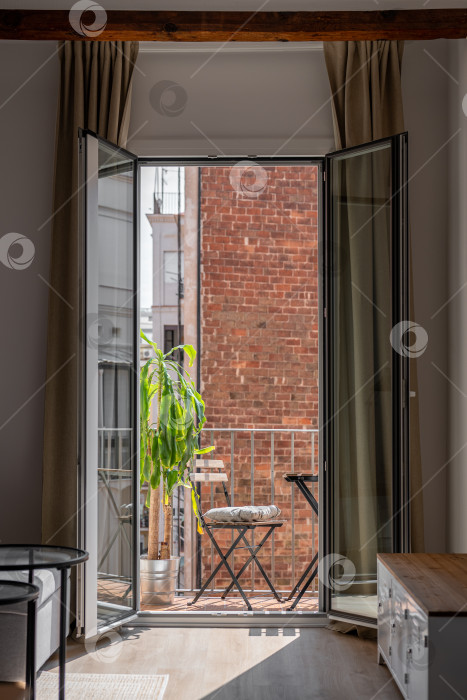 Скачать Открытая стеклянная дверь уютной террасы в отремонтированной квартире фотосток Ozero