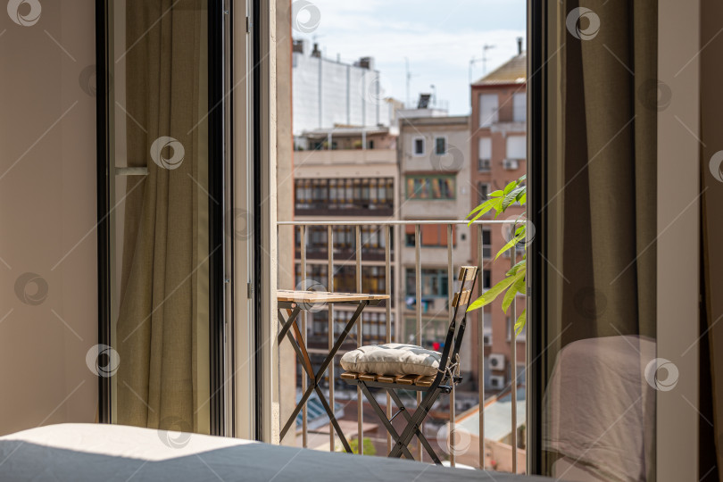 Скачать Небольшой столик и стул на солнечной террасе с видом из квартиры фотосток Ozero