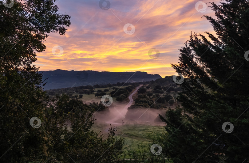Скачать Желтый рассвет с голубым небом в деревне с туманом фотосток Ozero