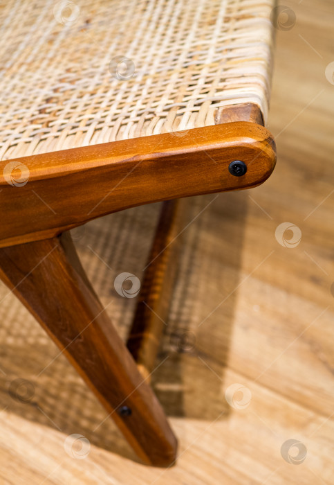 Скачать Деталь современного плетеного кресла, стоящего на ламинате. Внутренняя деревянная мебель. фотосток Ozero