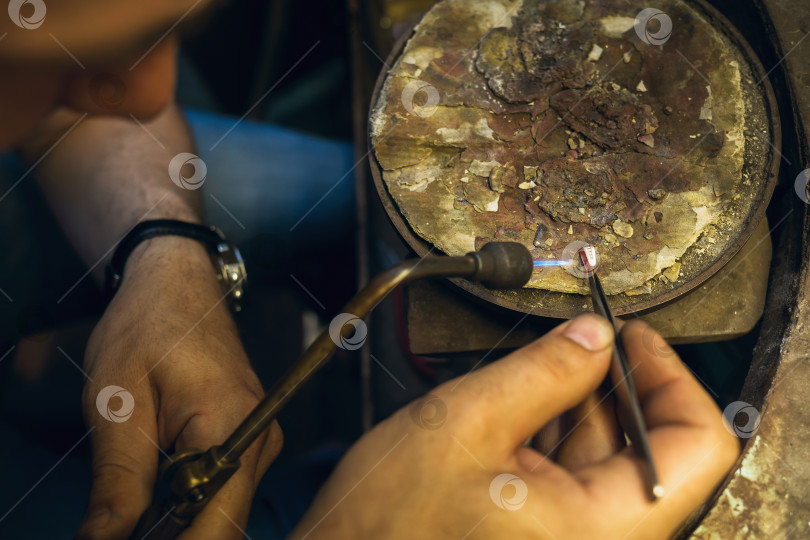 Скачать Ювелир расплавляет золотое изделие в процессе ремонта фотосток Ozero