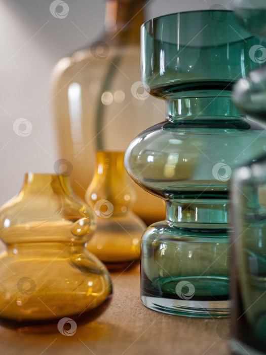 Скачать Крупный план стильных декоративных ваз из прозрачного стекла на деревянном столе. Оформление интерьера фотосток Ozero
