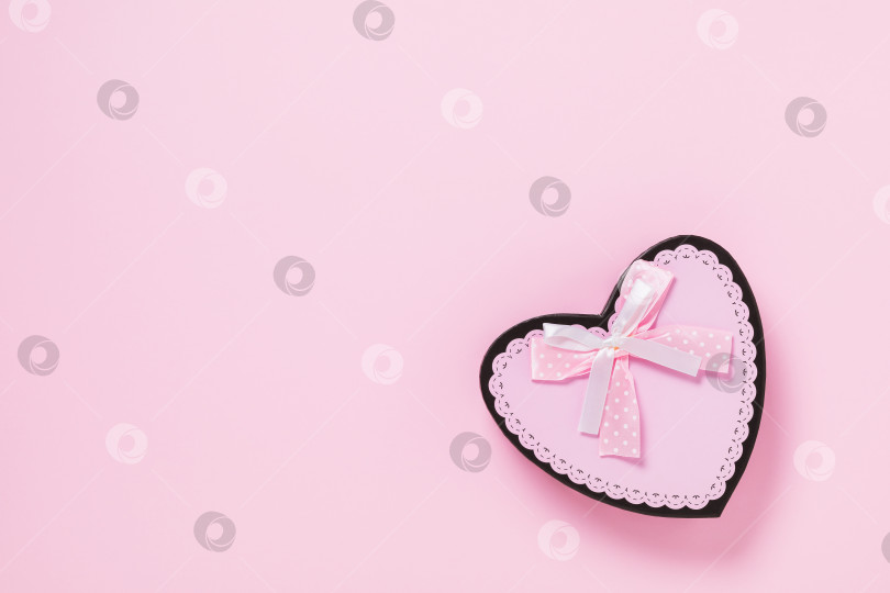 Скачать Подарочная коробка с бантом в форме сердца на розовом фоне с местом для копирования, вид сверху фотосток Ozero