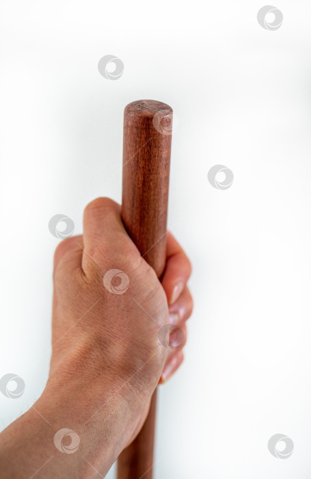 Скачать Мужская рука держит коричневую деревянную рукоятку на белом фоне фотосток Ozero