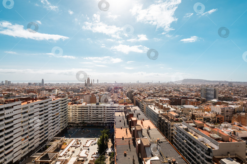 Скачать Вид с высоты птичьего полета на городской пейзаж Барселоны, демонстрирующий архитектурную красоту и яркий городской пейзаж с облаками на заднем плане фотосток Ozero