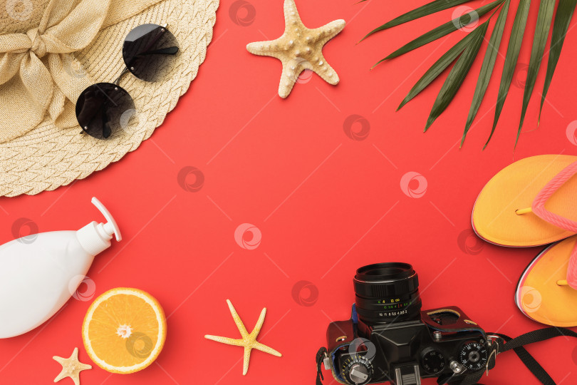 Скачать Шляпа, очки, пляжные тапочки, фотоаппарат и морская звезда на красном фоне с пробелом для копирования в центре фотосток Ozero