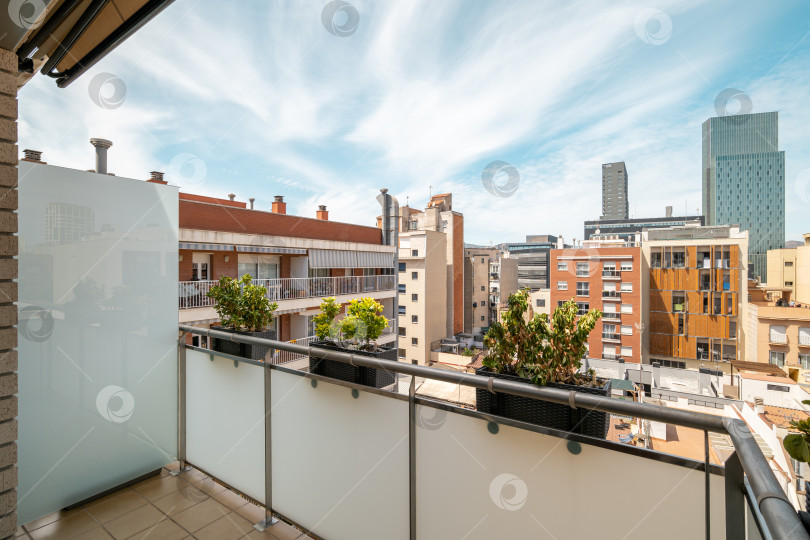 Скачать Вид с балкона на городскую архитектуру Барселоны среди живописного жилого района с затянутым облаками небом фотосток Ozero