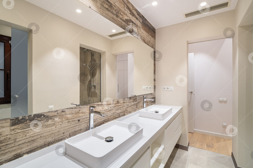 Скачать Современная ванная комната, отделанная кафелем, с душевой кабиной, двумя раковинами и большим настенным зеркалом фотосток Ozero