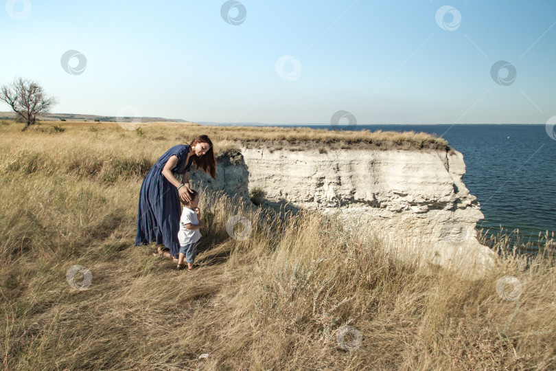 Скачать Молодая женщина гуляет в поле с маленьким ребёнком. фотосток Ozero