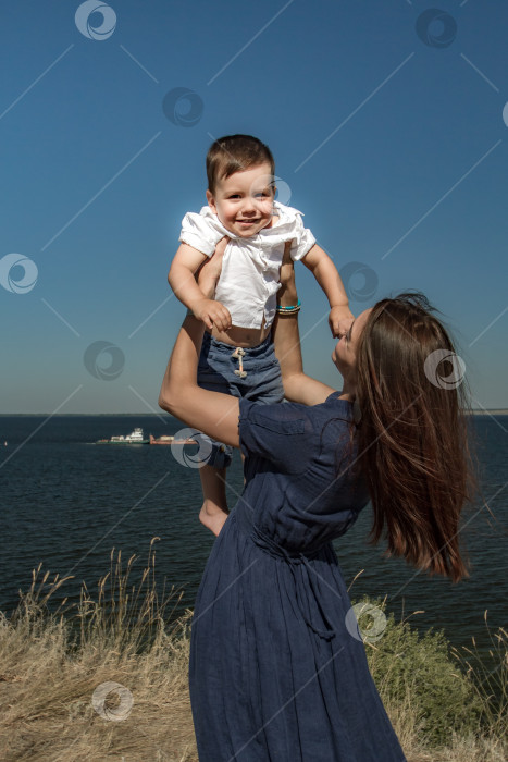 Скачать Молодая женщина держит в руках смеющегося ребёнка. фотосток Ozero