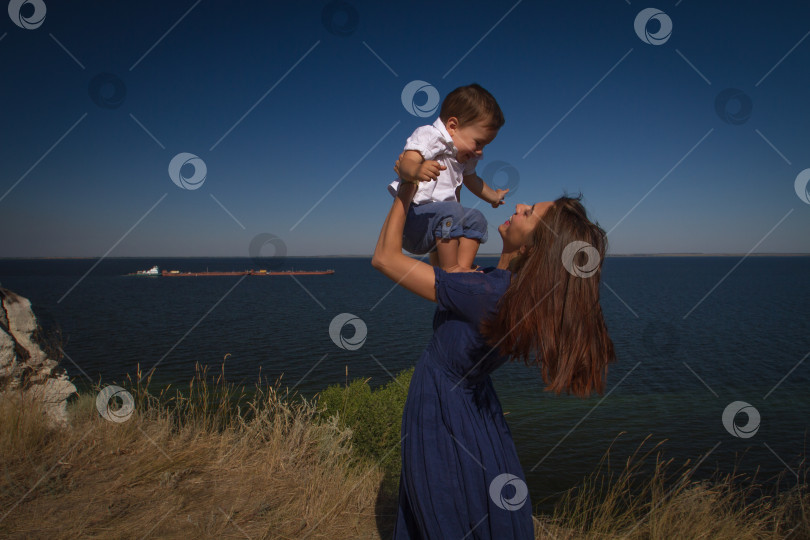 Скачать Молодая женщина держит в руках смеющегося ребёнка. фотосток Ozero