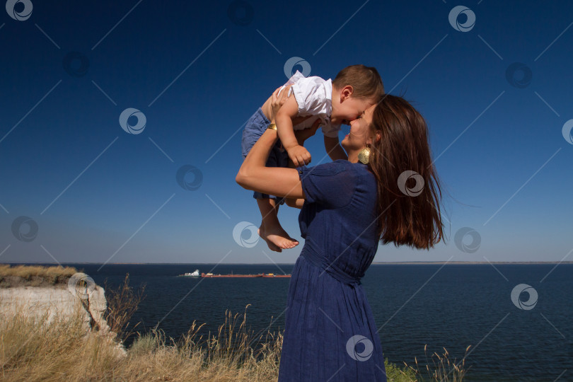 Скачать Молодая женщина держит в руках смеющегося ребёнка. фотосток Ozero