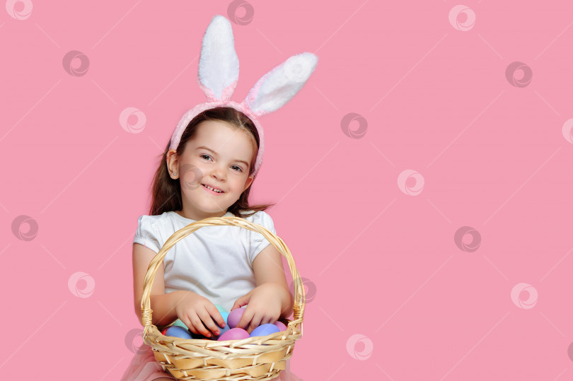 Скачать Девушка счастлива после охоты за яйцами на розовом фоне фотосток Ozero