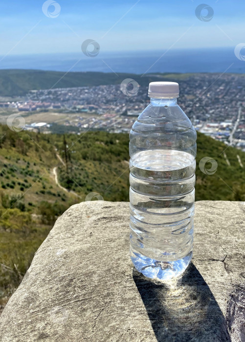 Скачать Бутылка с чистой водой на фоне природного пейзажа. Экология. Чистая вода. фотосток Ozero