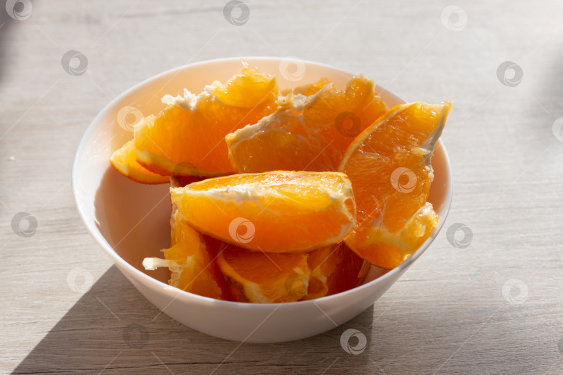 Скачать Изображение сочных дольок свежего апельсина в миске фотосток Ozero