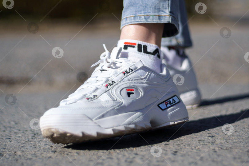 Скачать Тюмень, Россия - 23 сентября 2023 года: Обувь Fila, модель disruptor 2 white popular, снятая компаниями-производителями спортивной одежды для активного отдыха. фотосток Ozero