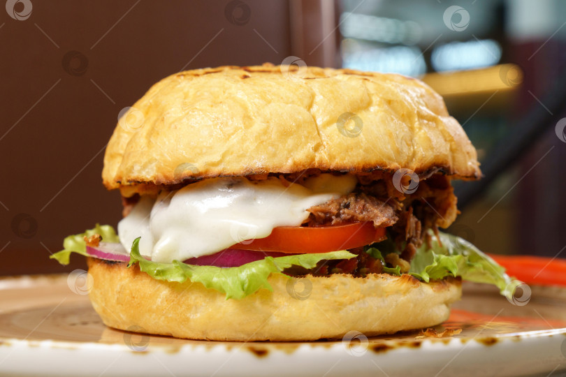 Скачать Бургер с говяжьим языком, сырным салатом и помидорами крупным планом. Выборочный фокус фотосток Ozero