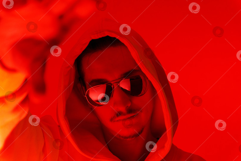 Скачать Студийный портрет мужчины-модели с усами и бородой крупным планом на красном фоне в солнцезащитных очках фотосток Ozero