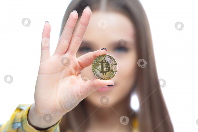 Скачать Крупный план физической криптовалюты биткойн, которую держит перед лицом в руке красивая женщина. Концепция финансового благополучия, роста, инвестиций фотосток Ozero
