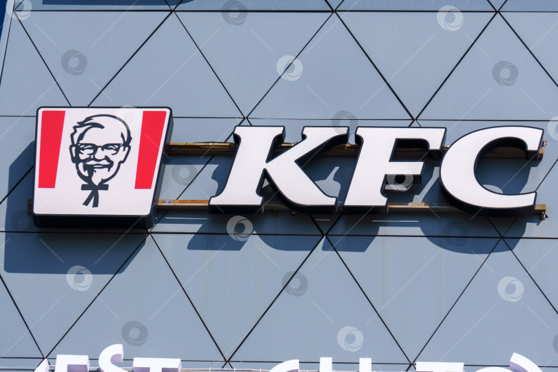 Скачать Тюмень, Россия-09 августа 2023 года: ресторан с логотипом KFC. KFC - популярная сеть быстрого питания, известная как Kentucky Fried Chicken фотосток Ozero