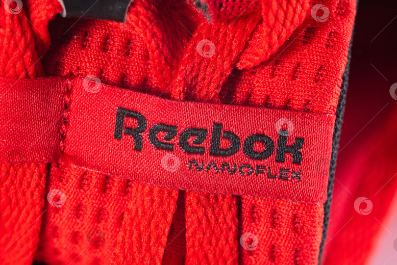 Скачать Тюмень, Россия - 11 октября 2023 года: Логотип красных кроссовок Reebok. Reebok - глобальная компания по производству спортивной обуви и одежды. фотосток Ozero