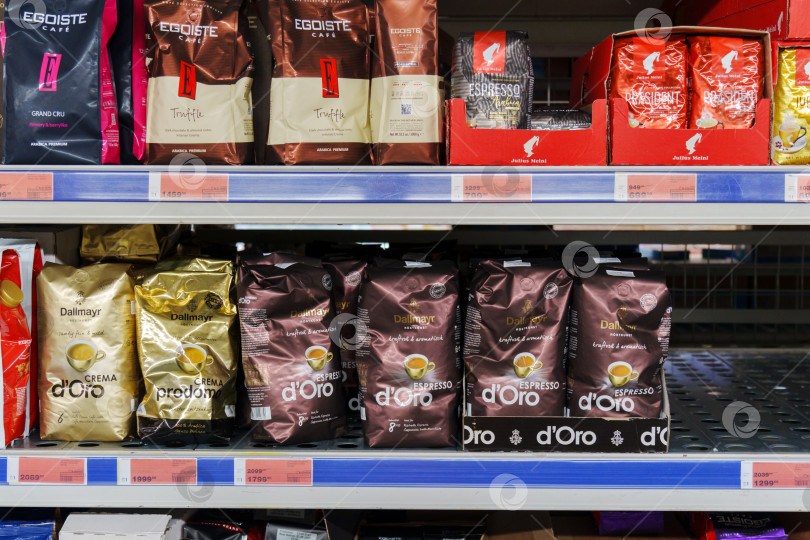 Скачать Тюмень, Россия - 04 ноября 2023 года: Полки продуктовых магазинов заполнены молотым кофе и цельными зернами в пакетиках с различными вкусами. фотосток Ozero