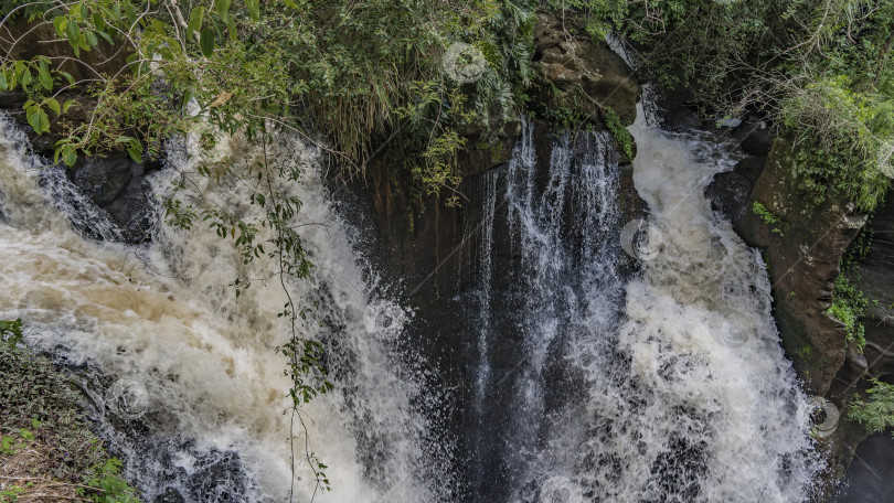 Скачать Бурные, закрученные потоки воды стекают по склонам скал. фотосток Ozero