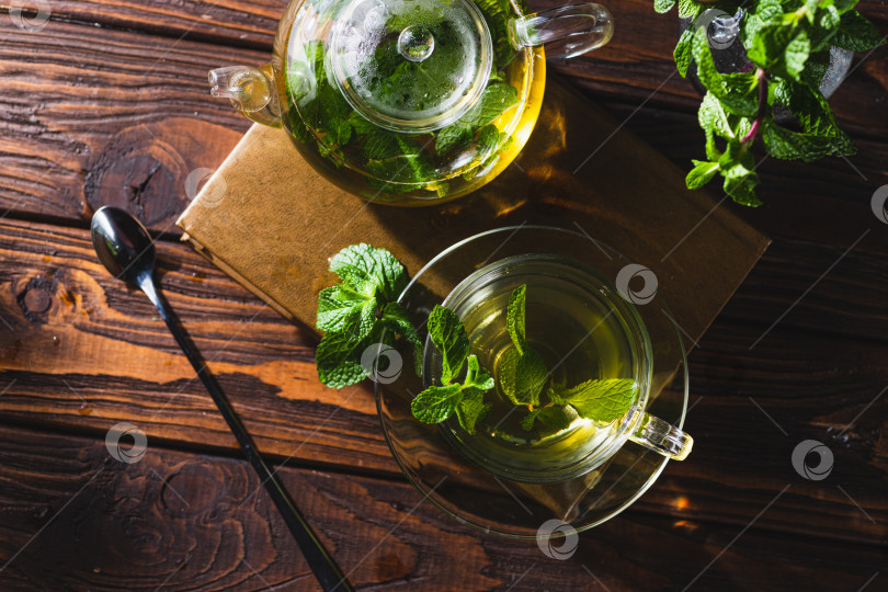 Скачать Мятный чай в чайнике и чашке на деревянном столе фотосток Ozero