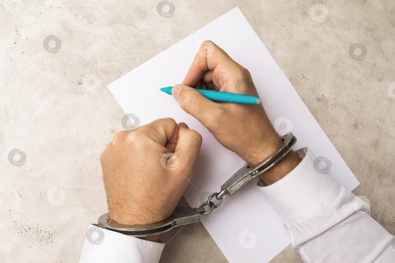 Скачать Человек в наручниках пишет завещание или признание в преступлении, концепция получения согласия под влиянием давления на людей фотосток Ozero