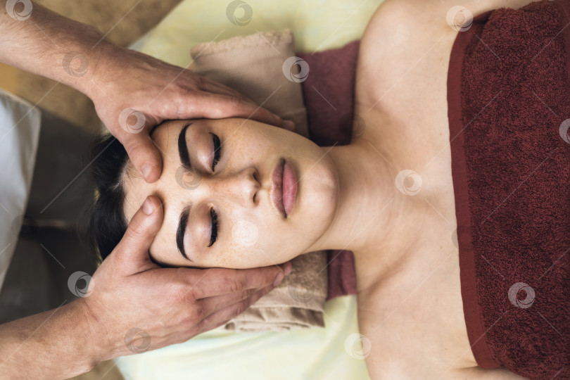 Скачать Мануальный терапевт выполняет расслабляющий массаж лицевых мышц женщине фотосток Ozero