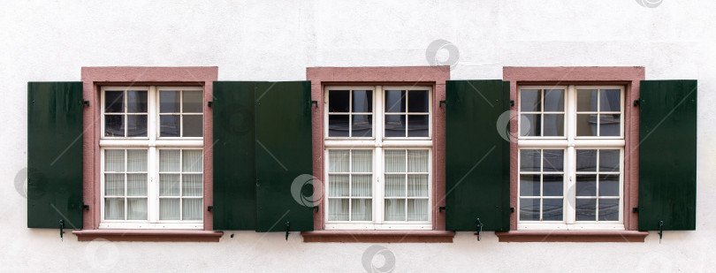 Скачать Три окна в ряд с темными металлическими ставнями фотосток Ozero