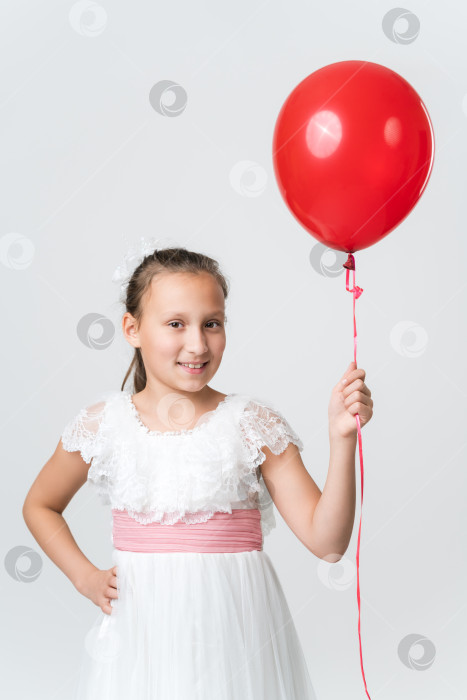Скачать Девушка в белом платье держит в руках красные воздушные шары, счастливо улыбается, глядя в камеру. Вид спереди фотосток Ozero