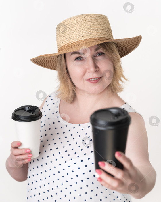 Скачать Блондинка держит в разных руках черно-белый бумажный стаканчик для кофе. Концепция выбора фотосток Ozero