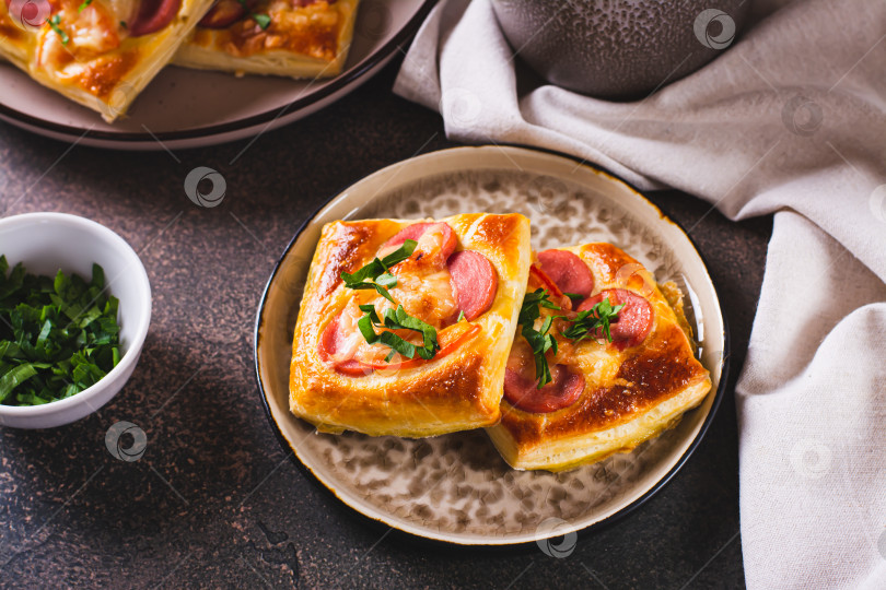 Скачать Квадратный мини-пирог, запеченный с помидорами, колбасой и сыром на тарелке для перекуса фотосток Ozero