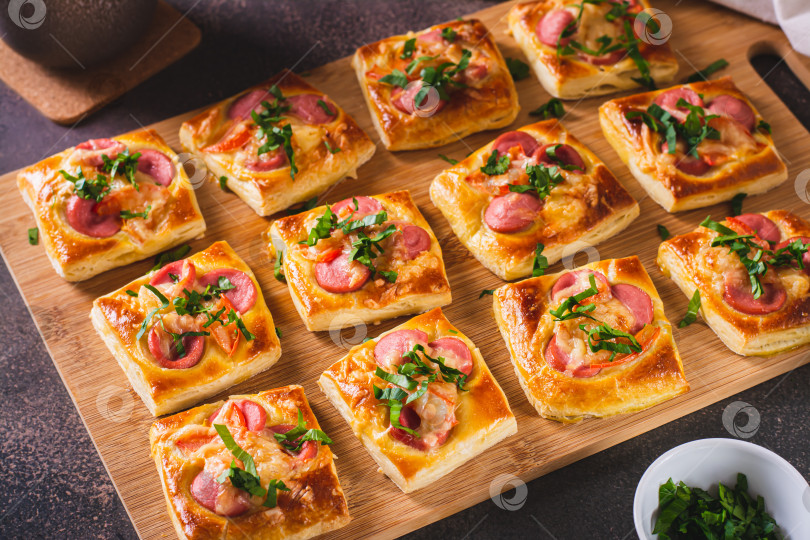 Скачать Закусочная мини-пицца с сосисками, помидорами и сыром на деревянной доске фотосток Ozero