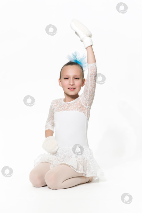 Скачать Девушка-балерина в белой юбке-пачке сидит на белом фоне фотосток Ozero
