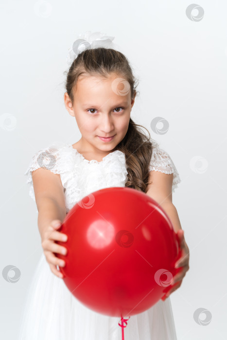 Скачать Вид спереди на игривую девушку, держащую обеими руками красный воздушный шар и смотрящую в камеру фотосток Ozero