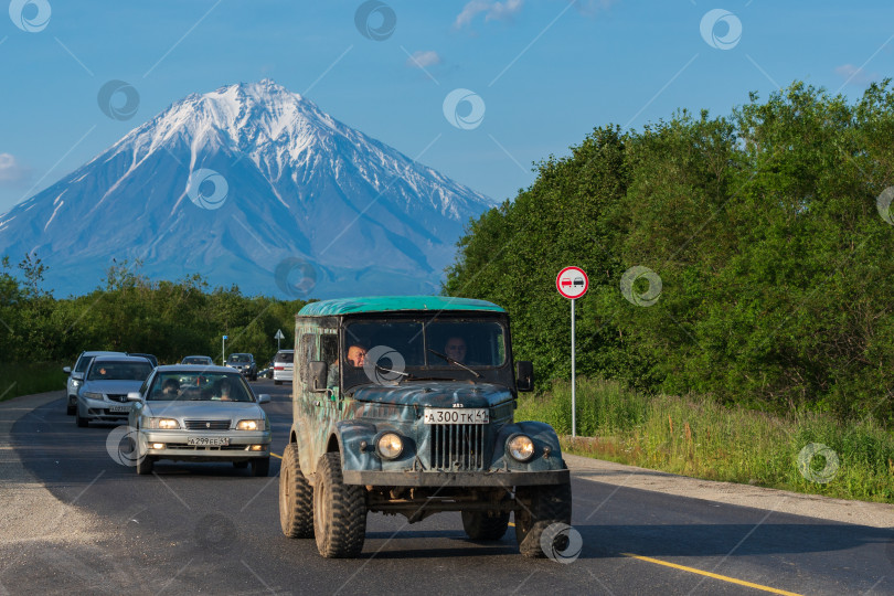 Скачать Старый советский полноприводный автомобиль, едущий по асфальтированной дороге на фоне летнего пейзажа фотосток Ozero