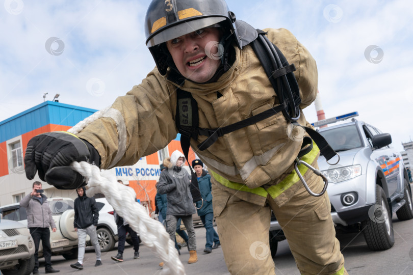 Скачать Пожарный-спасатель МЧС России буксирует автомобиль тросом на расстояние 50 м фотосток Ozero