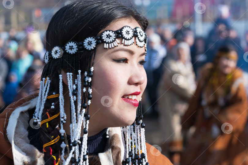 Скачать Портрет улыбающейся молодой женщины в традиционной одежде коренных жителей полуострова Камчатка. Празднование корякского национального ритуального праздника Хололо - Дня тюленя фотосток Ozero