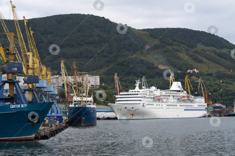 Скачать Летний вид на морской торговый порт - рыболовецкое судно и круизный лайнер у пирса фотосток Ozero
