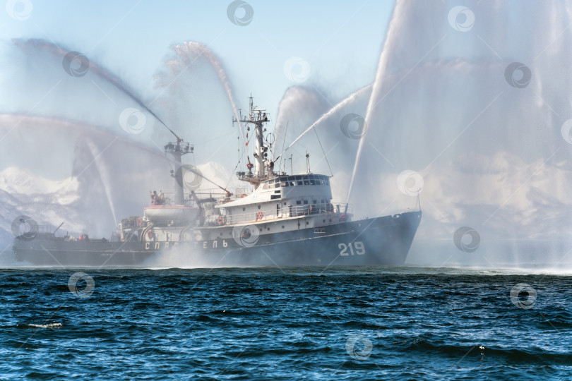 Скачать Пожарный корабль, разбрызгивающий воду в море для оказания экстренной помощи в случае пожара фотосток Ozero