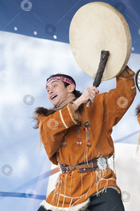 Скачать Танцовщица-аборигенка в национальной одежде коренных народов эмоционально танцует с бубном. Концерт корякского танцевального ансамбля Менго фотосток Ozero