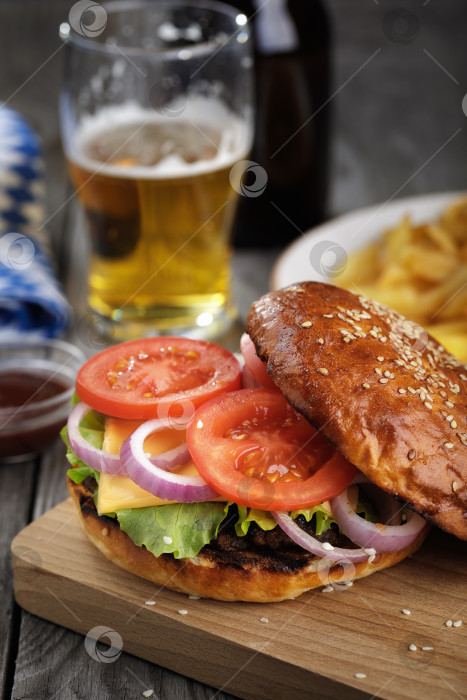 Скачать Вкусный гамбургер с овощами и котлетой. Бутерброд с пивом крупным планом фотосток Ozero