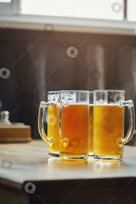 Скачать Четыре бокала светлого пива в баре на деревянном столе фотосток Ozero