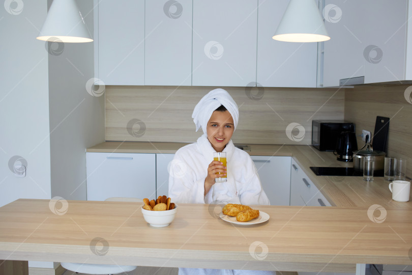 Скачать Улыбающаяся девушка в халате сидит на кухне фотосток Ozero