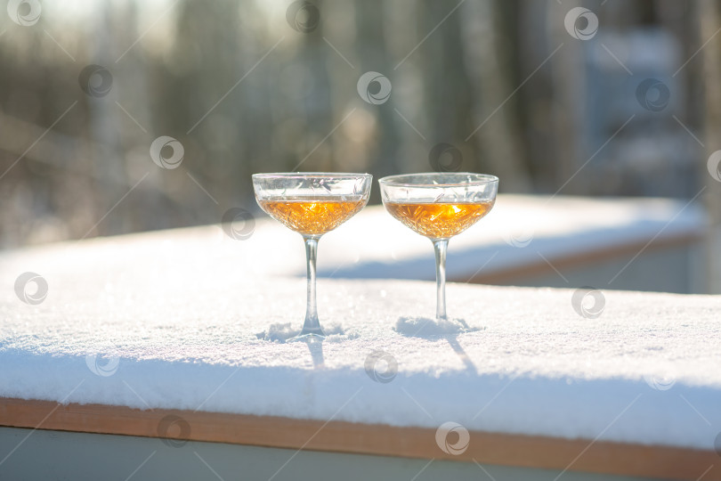 Скачать Два бокала шампанского на заснеженной скамейке фотосток Ozero